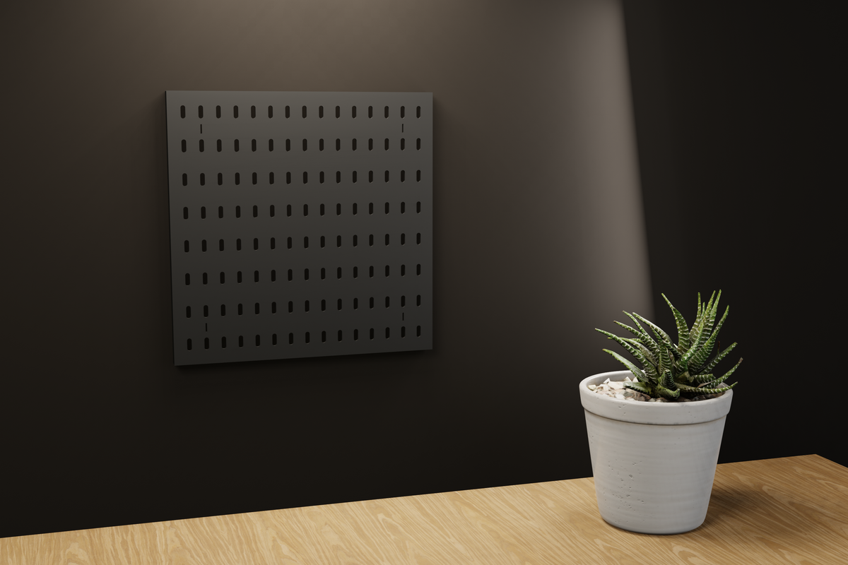 Panneau perforé iki noir au mur, bureau en chêne clair et plante